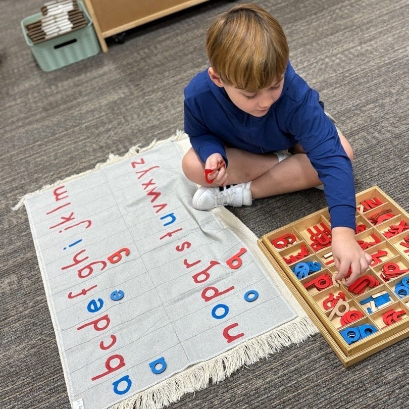 Child playing with alphabet letters on a mat and wooden set